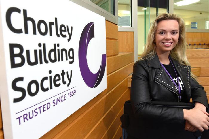 Staff member next to Chorley logo